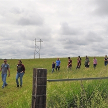 People walk in a field during event tour