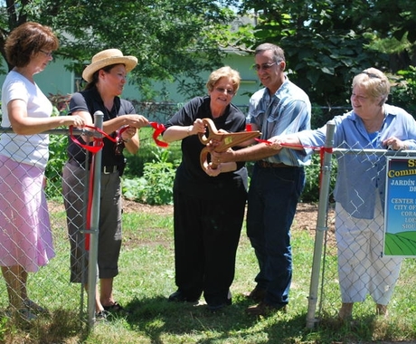 Folks cutting a ribbon to open a community garden