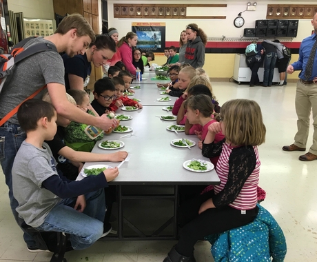 Children at lunch table eating salad