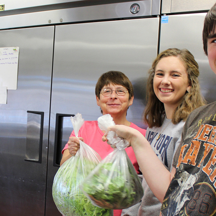 Students delivering lettuce to cafeteria supervisor