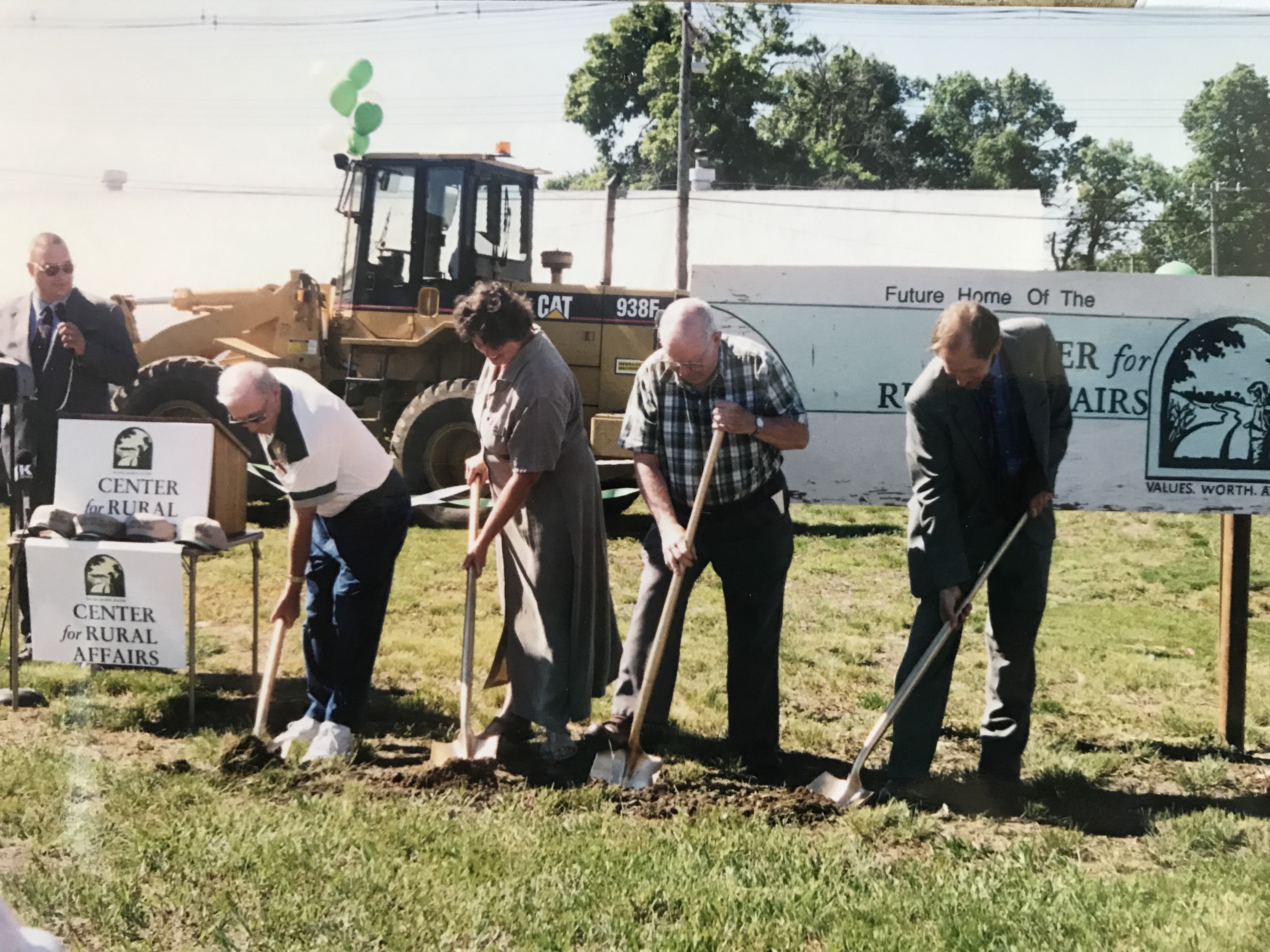 Four individuals shoveling dirt at a groundbreaking