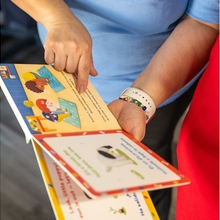 Un adult i un nen lien un llibre junts.