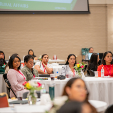 Una fotografía de cerca de cinco mujeres latinas mirando a la oradora