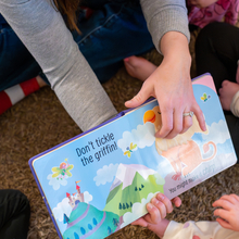 Caregiver reading a book to children