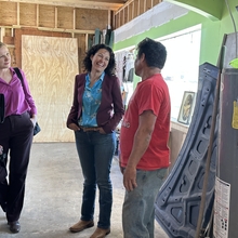 Three people talking inside a building under construction 