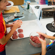 Two students forming ground elk meat for burgers