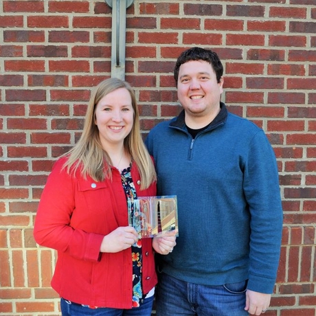 An image of a man and woman holding an award