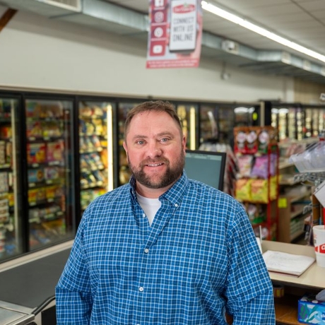 A man in a grocery store in a blue shirt