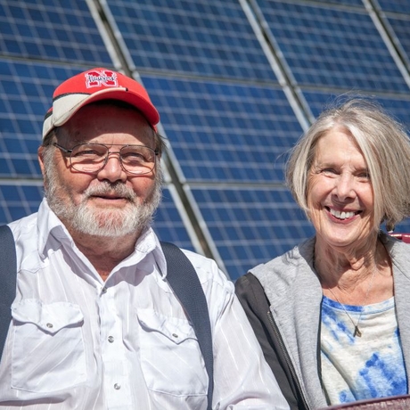 An image of a couple in front of solar panels