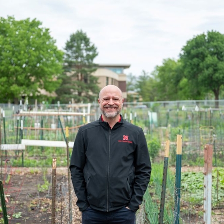 Photo of a man standing in front of a garden