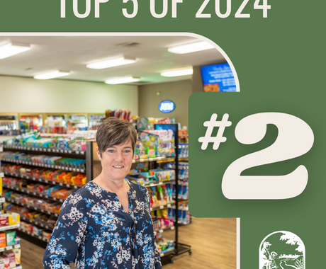 Graphic that says "Top 5 of 2024 #2" and photo: White woman with short brown hair wearing a dark flowered long sleeve top stands in the middle of a convenience store with lights above and products around her