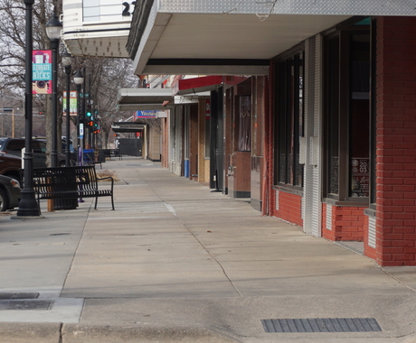 View from a sidewalk with business buildings on the right.