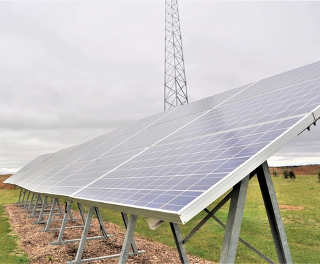 Solar array sitting on a green grass field.