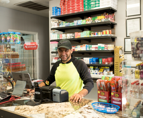 man standing behind counter, smiling