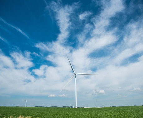 wind turbine in field with sky and clouds in background