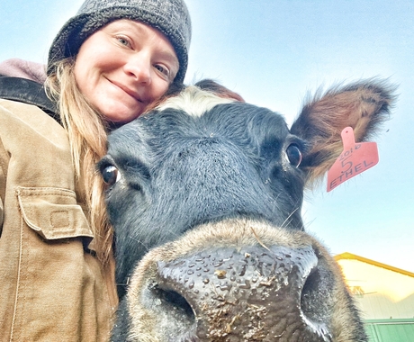 Woman hugging cow, with cow nose almost against camera