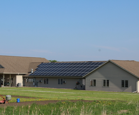 Large solar panel on the rooftop of a one-story multi-family building