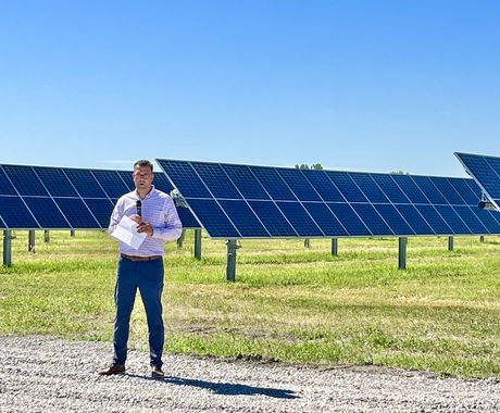 Mayor speaking in front of solar panel development 