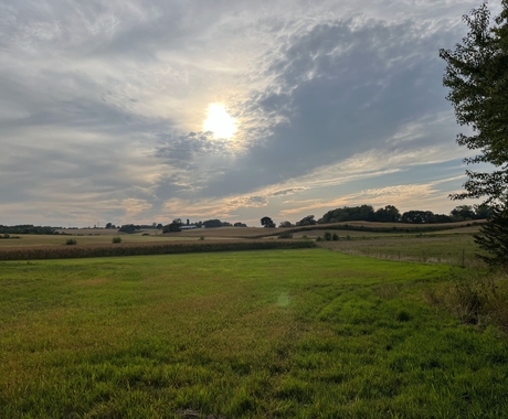 rural landscape with the sun shining through the clouds.
