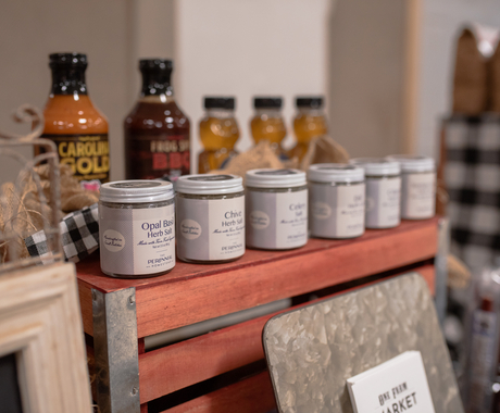 Jars of spices, sauces, and honey on display.