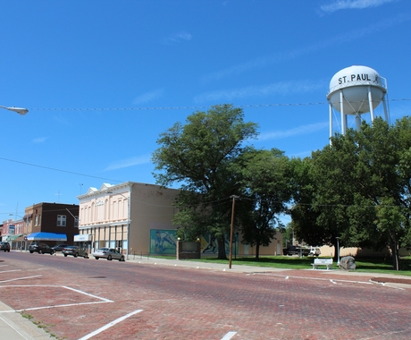 Small town main street with buildings and a water tower on the right. 