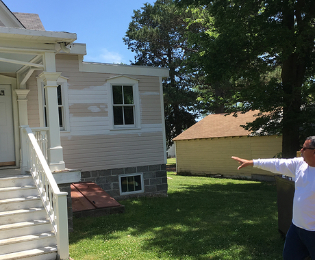 Man showing woman front of historic house