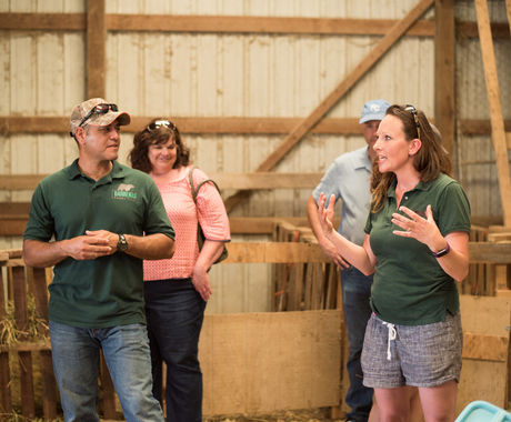 Man and woman leading farm tour in barn