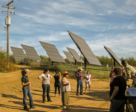 People in front of solar panels