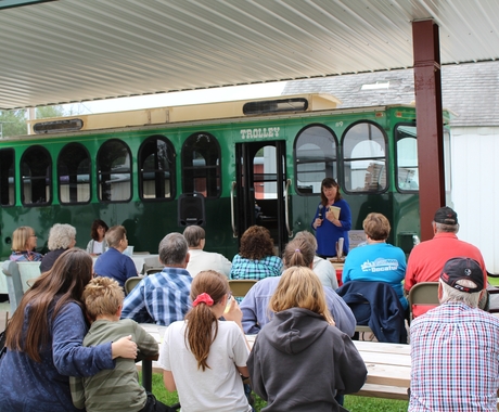Group watching author present outside of a trolly