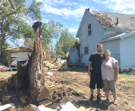 Man and woman in front of wind damage