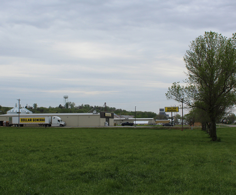 Dollar General building with Dollar General Truck in front at edge of town