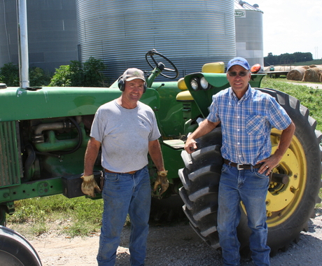 Two farmers in front of their tractor