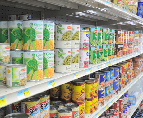 canned goods on a grocery store shelf. 