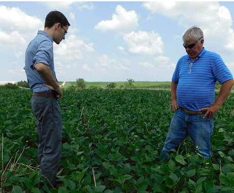 younger man and older man standing in field