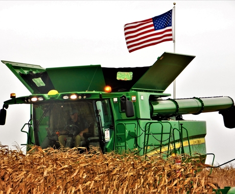 Combine during harvest with American flag