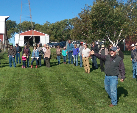 Man leading farm tour in front of barn