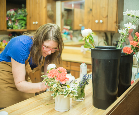 woman in glasses arranging flowers