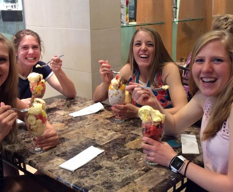 Four teenage girls eating at restaurant