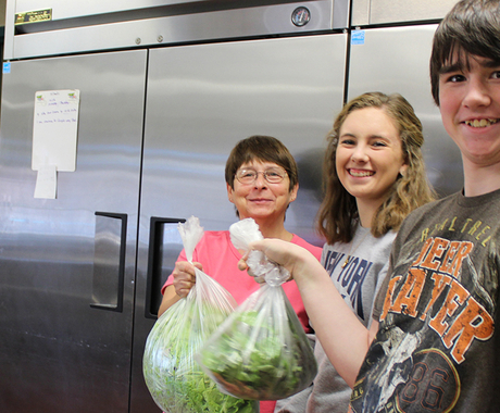 Students delivering lettuce to cafeteria supervisor