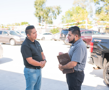 Two men standing and talking outside