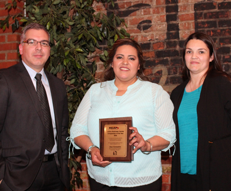Man and two women with award