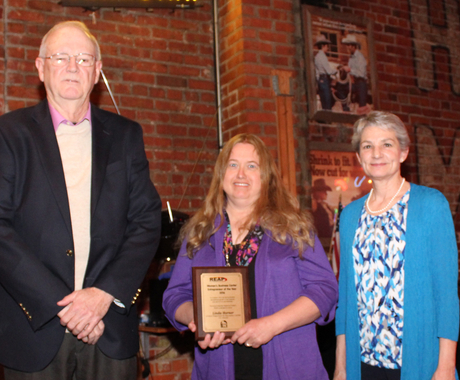 Man and two women with award