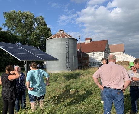 People gathered around solar panels 