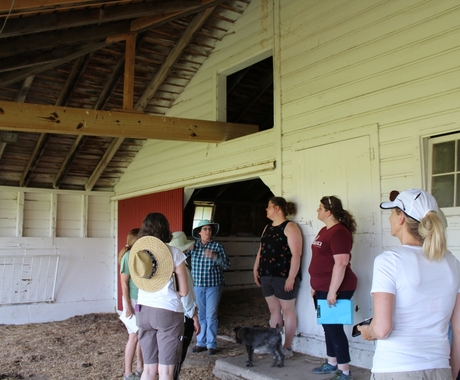 Women converse in a circle in a white barn