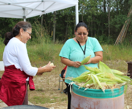 Two women shucking Indian corn