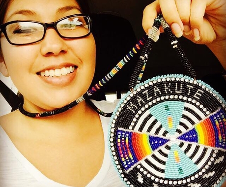 Kady Strickland holding medallion with beadwork