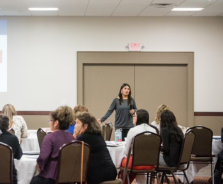 Woman speaking in front of group of people
