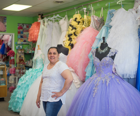 Woman posing in front of dresses