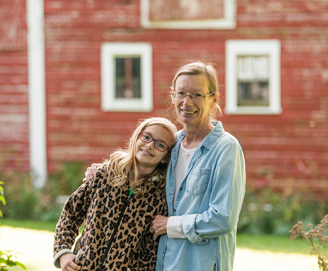 Woman with granddaughter in front of barn