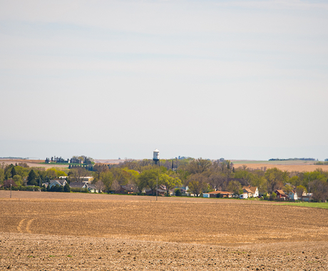 A small town from afar, with a brown field in front